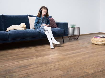 Mädchen hört Musik im Wohnzimmer mit Bodenfliesen Urban Caramel
