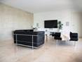 Travertin Classic Light: geradlinig & elegant Modernes Wohnzimmer mit schwarzen Couchmöbeln und hellbeigen Travertinfliesen Classic Light als Bodenbelag